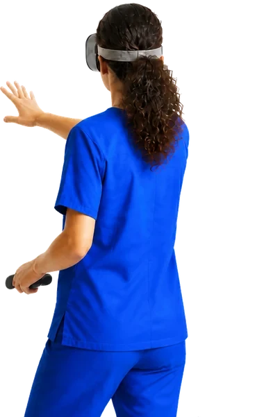 A nursing student seen from behind wearing a virtual reality headset, one hand raised toward something only she can see and a controller in the other